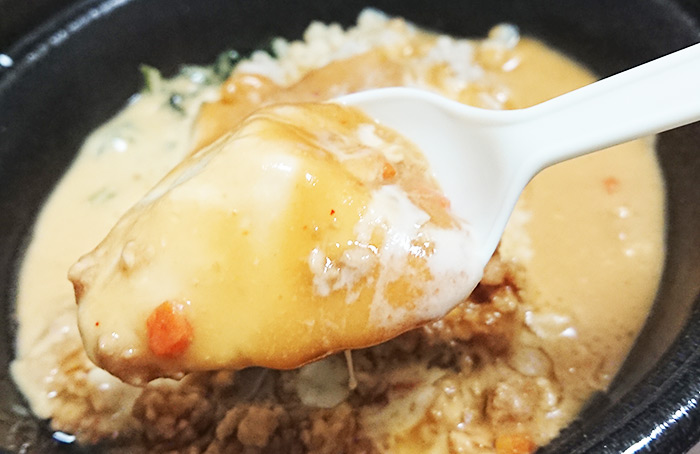 「肉味噌チーズ(もち麦入り)」の豆腐をスプーンですくった写真
