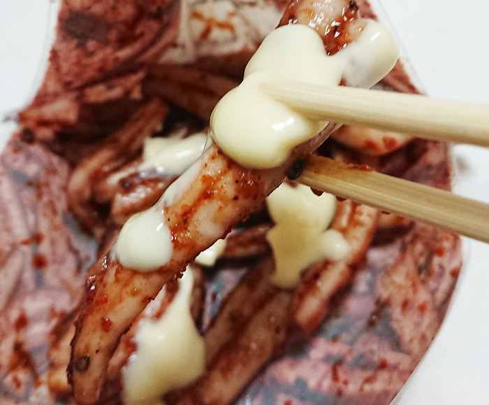 「イカの柚子七味焼き」にマヨネーズを付けて箸でつまんだ写真