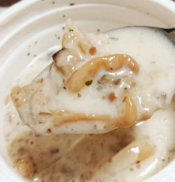 「たっぷりきのこの濃厚クリームスープ」のスープときのこをスプーンですくった写真