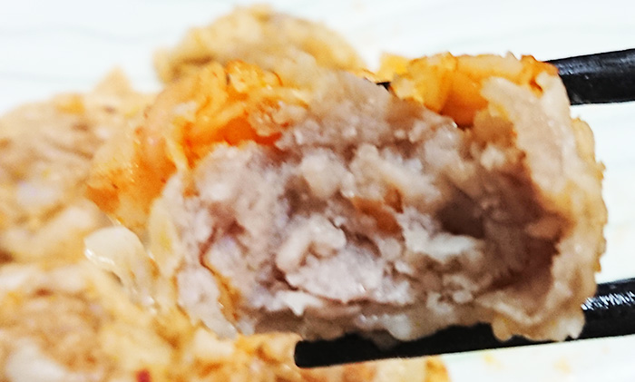「麻辣醤が決めて！おつまみ焼売」のシューマイを半分食べて中を撮った写真